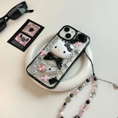 A Hello Kitty themed phone case with a black bow design, displayed alongside a box, sunglasses, and decorative beads.