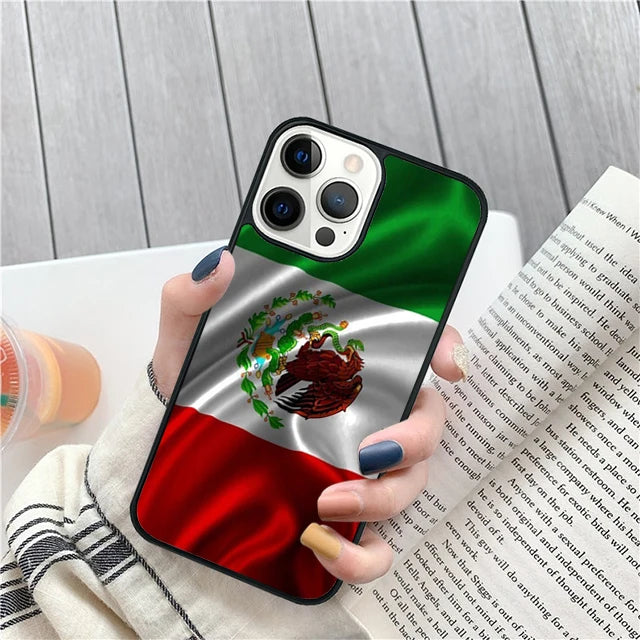 Phone case with Mexican flag design held by a person, with a book and drink in the background.