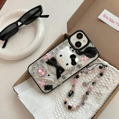 A Hello Kitty themed phone case with a black bow design, displayed alongside a box, sunglasses, and decorative beads.