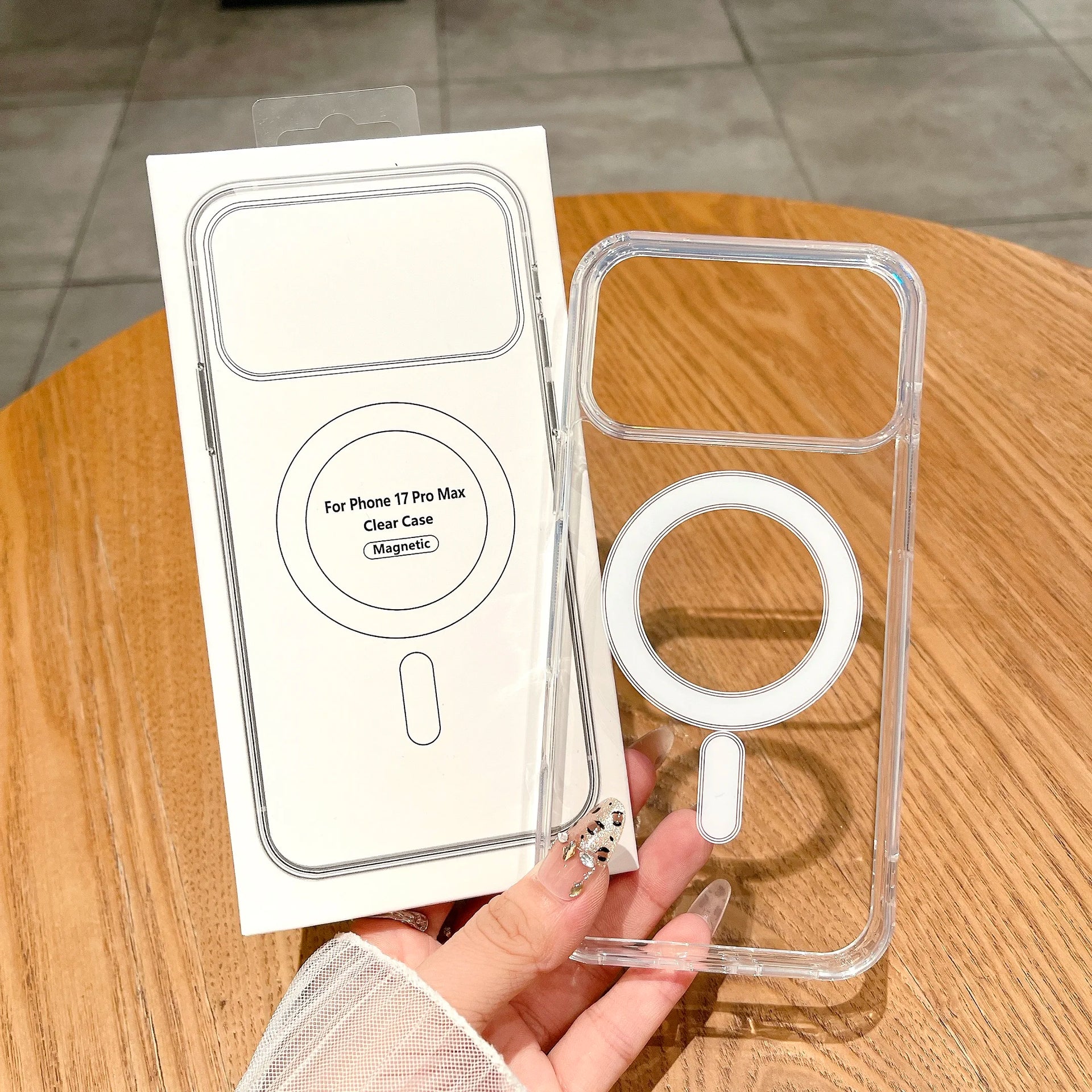 Clear phone case for iPhone 17 Pro Max with packaging on a wooden table