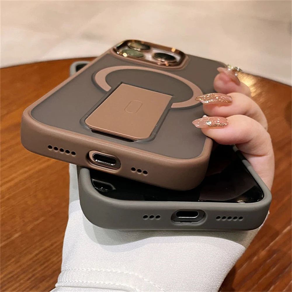 Person holding a phone with a protective case on a wooden surface
