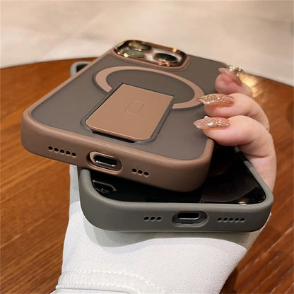 Person holding a phone with a protective case on a wooden surface
