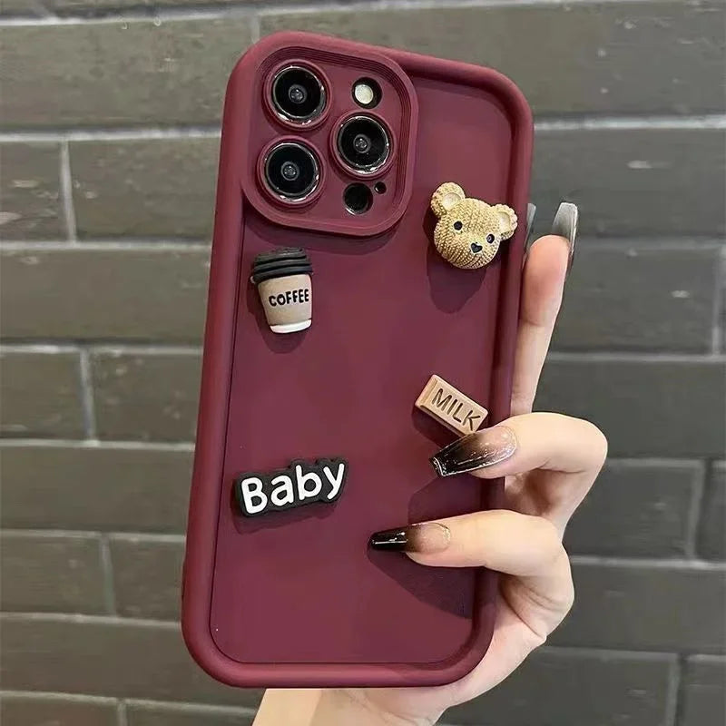 This image features a custom iPhone case with a playful 3D cartoon design. The case is predominantly white and showcases a series of raised elements including a bear, a camera, and text that reads "Baby" and "Milk".
