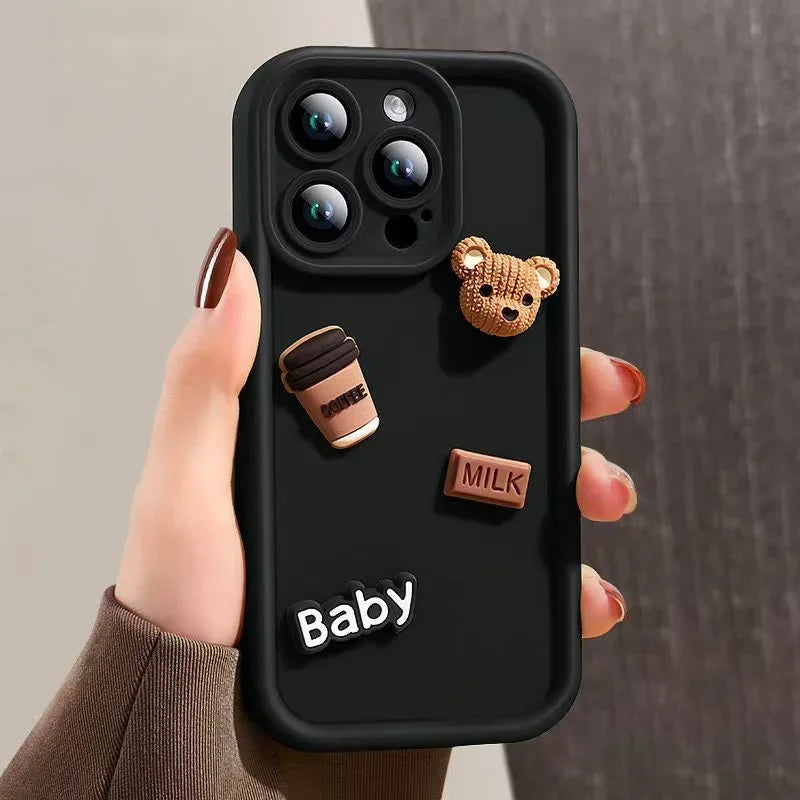 This image features a custom iPhone case with a playful 3D cartoon design. The case is predominantly white and showcases a series of raised elements including a bear, a camera, and text that reads "Baby" and "Milk".